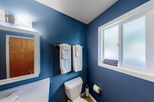 凯阿奥Hale Kai的蓝色的浴室设有卫生间和窗户。