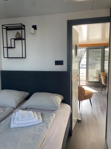 蒙尼肯丹Houseboat De Amstel的卧室配有一张壁挂镜子的床