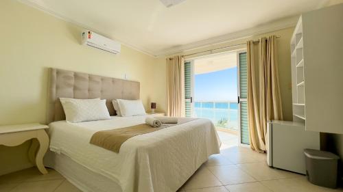 邦比尼亚斯Pousada Azores Bombinhas的一间卧室设有一张床,享有海景