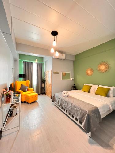 董里Triple J hotel Trang的一间卧室配有一张大床和一张黄色的沙发