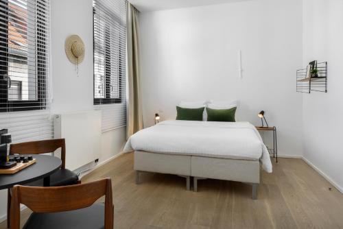 安特卫普The 1880 Residence by Domani Hotels的白色卧室配有带绿色枕头的床