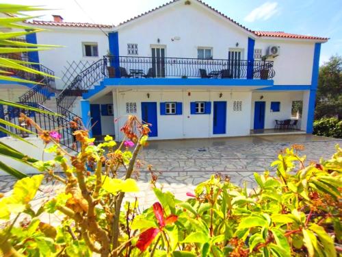 米尼亚spasmata houses的一座带蓝色门的房屋和一座种植了植物的院子