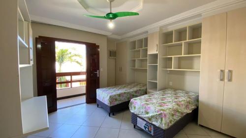 瓜拉派瑞Casa Paris 481 - Sua Mansão na Praia do Morro的一间卧室配有两张床和吊扇