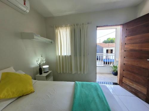 福塔莱萨Teto Hospedagens的一间卧室设有一张床和一个大窗户