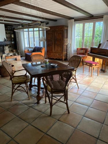 MoutierLa maison du petit bonheur的客厅配有桌椅和钢琴