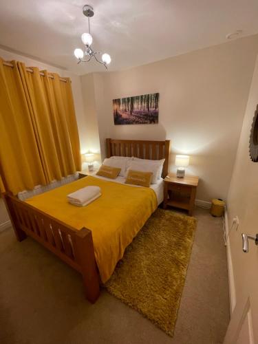 卡迪夫Holiday Home In Cardiff. Sleeps 6的一间卧室配有一张带黄色床罩的大床