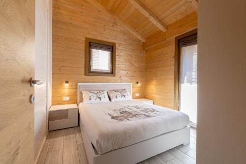 利维尼奥Ivan House的卧室配有木墙内的一张床