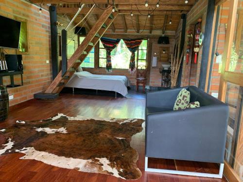 里奥内格罗Rancheria Loft Chalet, lago privado的一间设有床和沙发的房间,还有树 ⁇ 