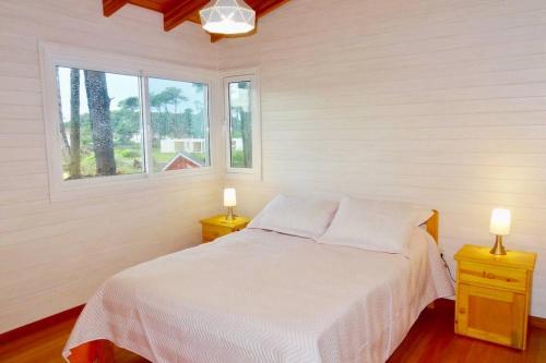 埃斯特角城Klimatisiertes Haus am Meer in Chihuahua的卧室配有白色的床和2个床头柜