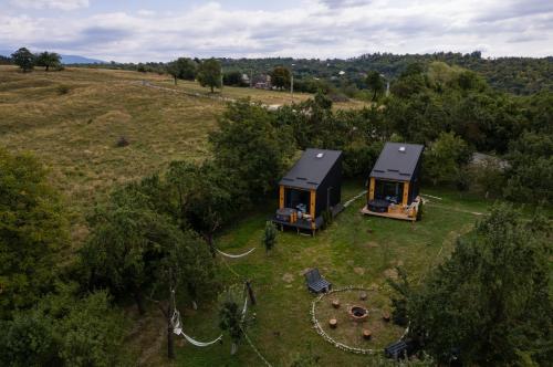 肯普隆格Campolongo Tiny Chalet的田野上两栋小屋的空中景观