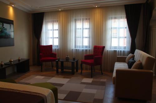 伯萨莉娜中央公寓 的客厅配有红色椅子、沙发和窗户