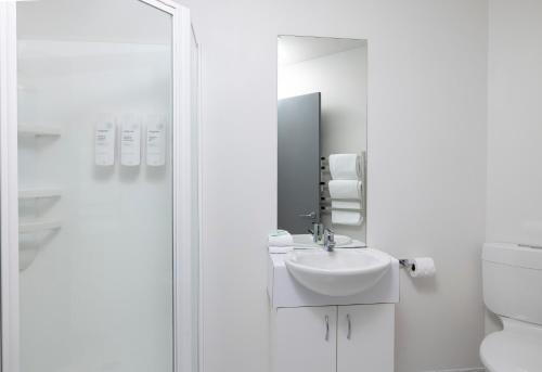 惠灵顿特雷斯街奎斯特服务公寓的白色的浴室设有水槽和镜子