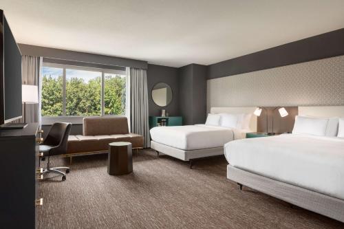 林夕昆高地巴的摩尔华盛顿机场希尔顿酒店的酒店客房设有两张床和窗户。