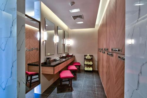 内比都奈比多希尔顿酒店的浴室设有红色凳子和带镜子的梳妆台