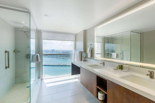 圣胡安卡里波希尔顿酒店的一间带两个水槽和玻璃淋浴间的浴室