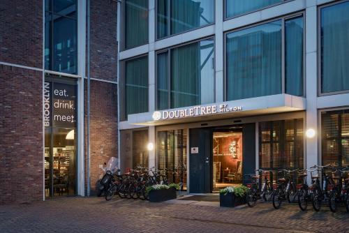 阿姆斯特丹DoubleTree by Hilton Amsterdam - NDSM Wharf的一座建筑物外停有自行车