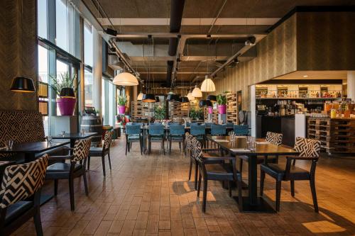 阿姆斯特丹DoubleTree by Hilton Amsterdam - NDSM Wharf的一间带桌椅的餐厅和一间酒吧