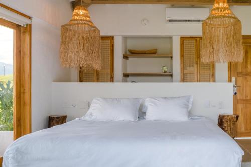 亚美尼亚Rancho Eden的一间卧室配有白色的床和2个吊灯
