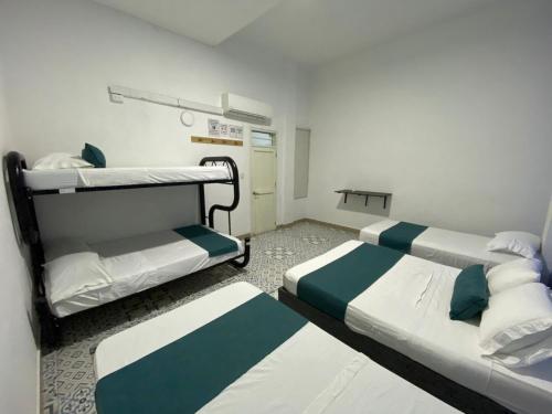 圣玛尔塔Believer Hostel的一间医院间,配有两张床和一张桌子