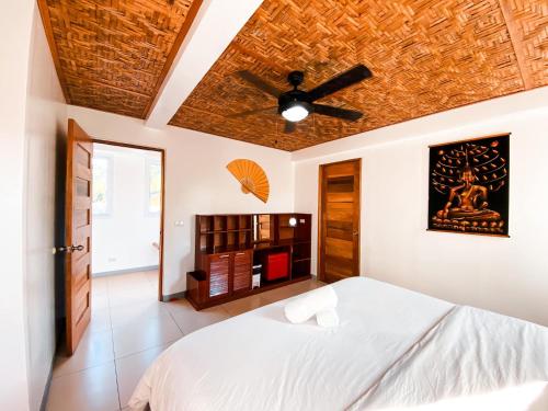 班塔延岛In Dai Aquasports and Beach Resort的一间卧室配有一张床和吊扇