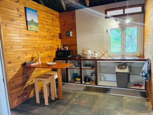 莫雷阿Bungalow KURA的厨房配有木墙、桌子和水槽