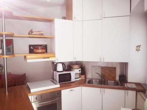 安杰拉Residenza Esse的厨房配有白色橱柜、水槽和微波炉
