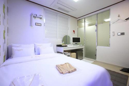 首尔Itaewon A One Hotel的一间卧室配有一张床和一张带电脑的书桌