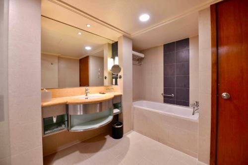 吉隆坡吉隆坡协和酒店的浴室配有盥洗盆和浴缸。