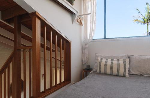 扬巴Pippi Beach Loft的一间卧室配有一张床和一个楼梯间