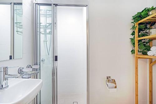 黄金海岸'Buzzing Surfers' Vibrant Indoor-outdoor Lifestyle的一间带玻璃淋浴和水槽的浴室
