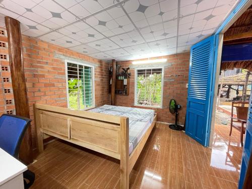 Tây NinhVong Nguyet Homestay - Entire Bungalow 36m2的一间卧室设有一张床和砖墙