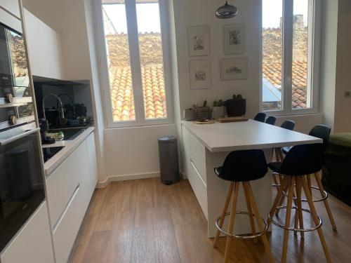 马赛Appartement Design sur Vauban - Clim et Wifi的一间厨房,内设一个柜台和凳子