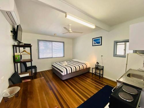伊鲁卡Koala Lodge Studio 1的一间卧室配有一张床,铺有木地板