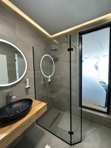 比哈奇Hotel GOLD JET Bihać的浴室设有玻璃淋浴间、水槽和镜子