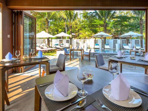 会安Hoi An Ocean Front Hotel的一间带桌椅的餐厅和庭院