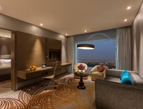 斋浦尔斋浦尔市中心假日酒店的酒店客房设有沙发、床和窗户。