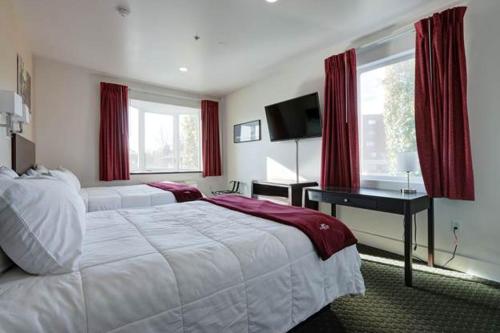 安克雷奇帕芬旅馆的卧室配有一张白色大床和一张书桌