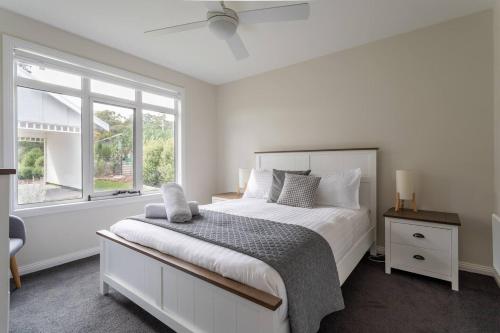 GoodwoodDerwent River Cottage - Tranquil Waterfront Living的白色的卧室设有一张大床和一个窗户