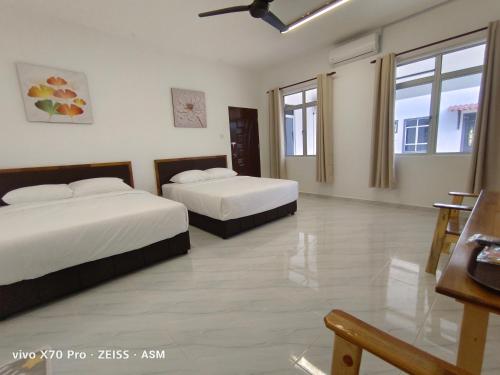 瓜拉丁加奴ASM Roomstay-4-2 Queen Beds的酒店客房设有两张床和一张桌子。