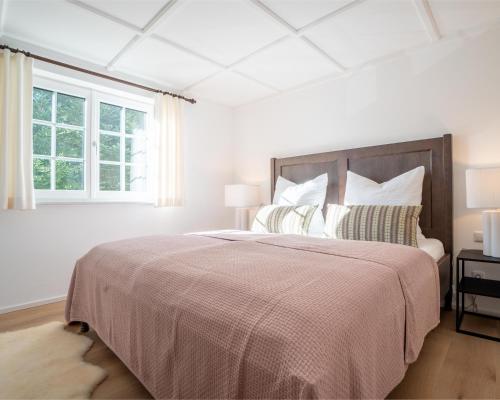 巴德哥依斯恩Strickerl的白色的卧室设有一张大床和一个窗户