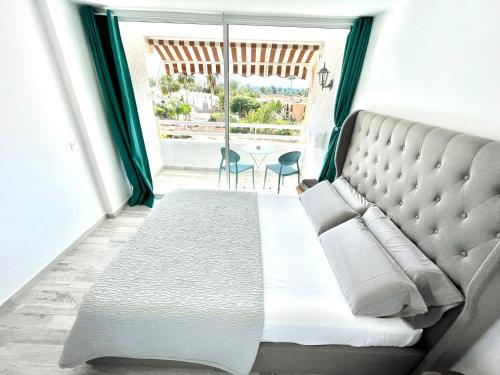 美洲海滩Borinquen Vista Mar的一间卧室设有一张大床和一个大窗户