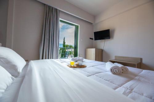 波罗斯Evita's Resort的卧室配有一张大白色床和窗户