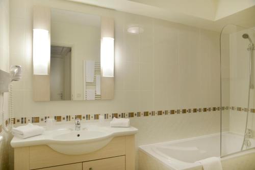 迪沃讷莱班Adonis Divonne-Les-Bains Résidence Du Lac的一间带水槽、浴缸和镜子的浴室