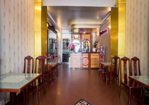 胡志明市Tan Hoang Long Hotel的餐厅内带桌椅的用餐室