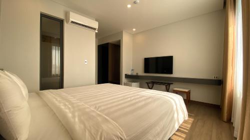 Uông Bí Boutique Hotel的卧室配有白色的床和平面电视。