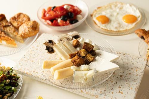 尼尔大卫尼尔大卫乡村酒店的餐桌上放有奶酪和其他食物的盘子