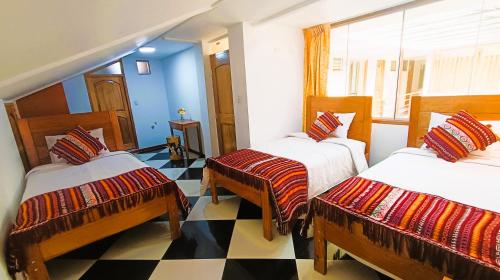 皮萨克Hotel Inka Pisac的带三张床的客房和 ⁇ 板地板