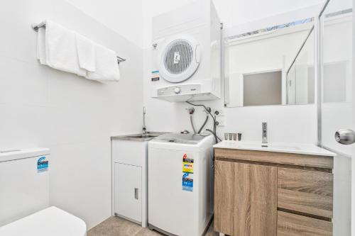 悉尼APX帕拉马塔公寓式酒店的一间带冰箱和水槽的小厨房