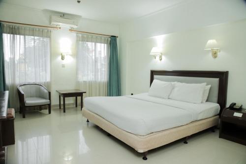 棉兰棉兰大酒店的卧室配有1张床、1张桌子和1把椅子