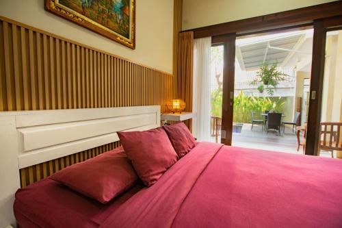 坎古愉快德维旅馆的一间卧室配有一张带粉色毯子的大床